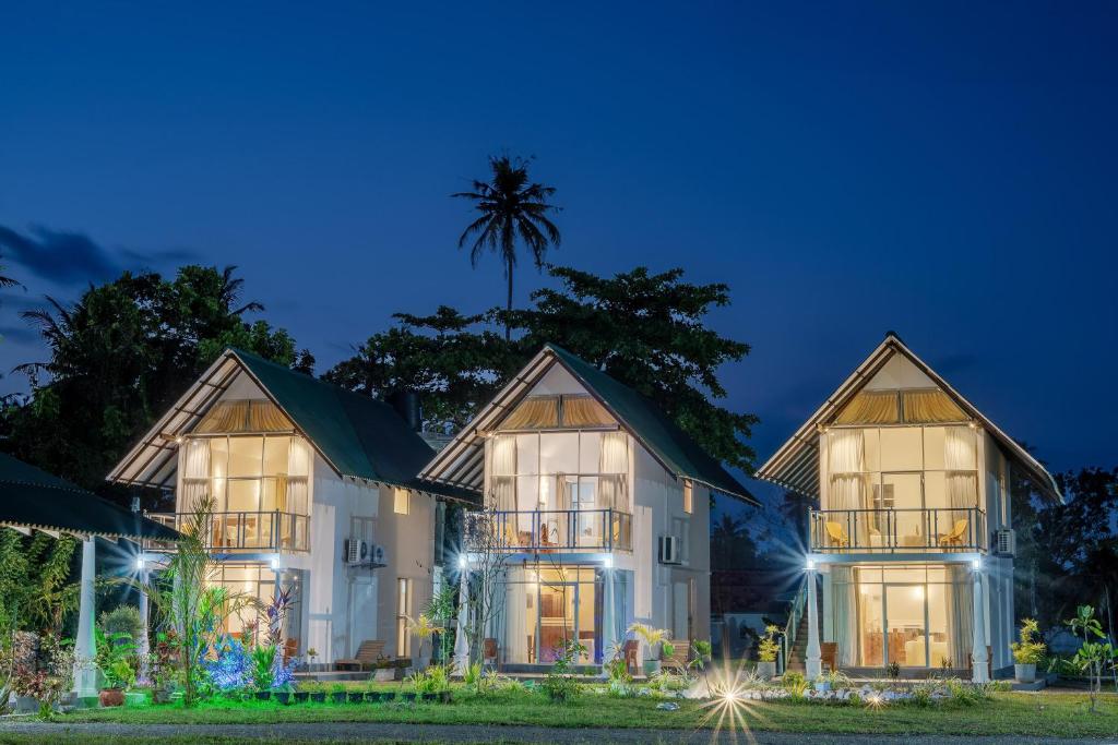 a villa with two large buildings at night at Madiha Beach Resort in Matara