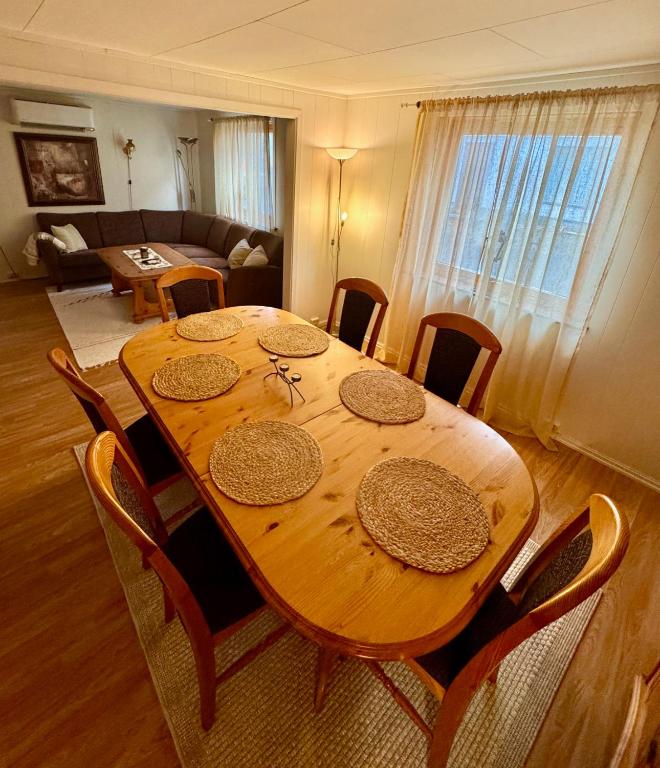 a wooden table and chairs in a living room at Fjord Haven in Gryllefjord