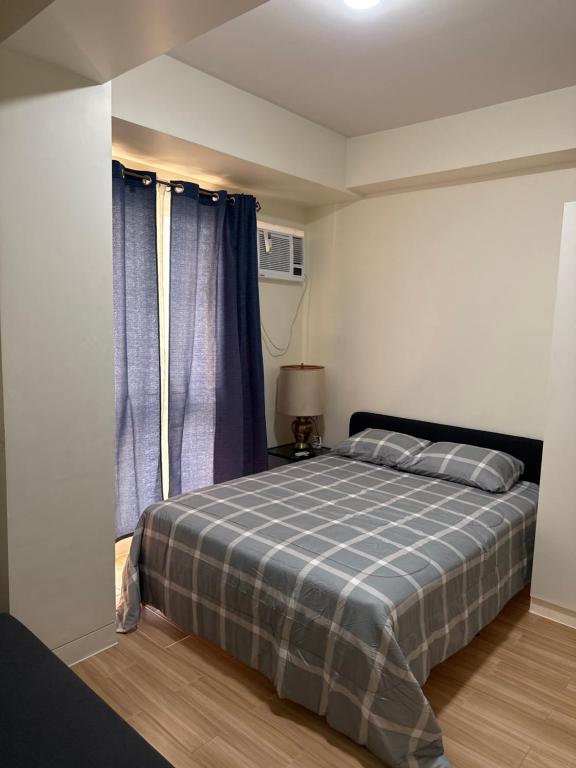 a bedroom with a bed with a blue plaid blanket at Rito in Jalang