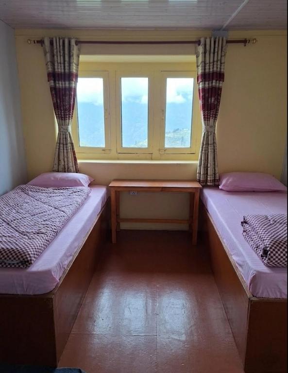 a room with two beds and a window at Fast food in Lukla
