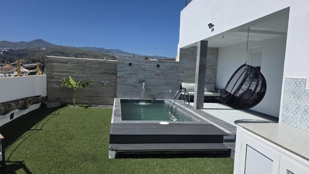 a small backyard with a swimming pool and a garden at Casa TataDora in Arucas