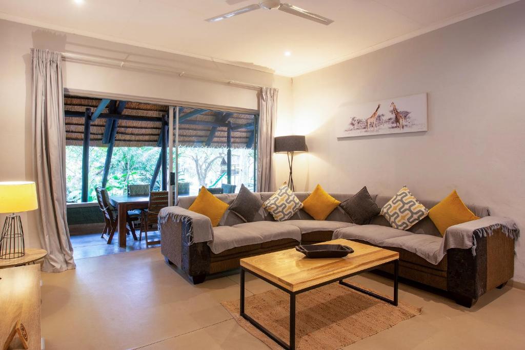 a living room with a couch and a table at Kingfisher Creek Safari Cottages in Hoedspruit