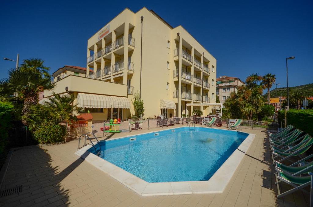 ein Hotel mit einem Pool vor einem Gebäude in der Unterkunft Residence Villa Gloria in Borgio Verezzi