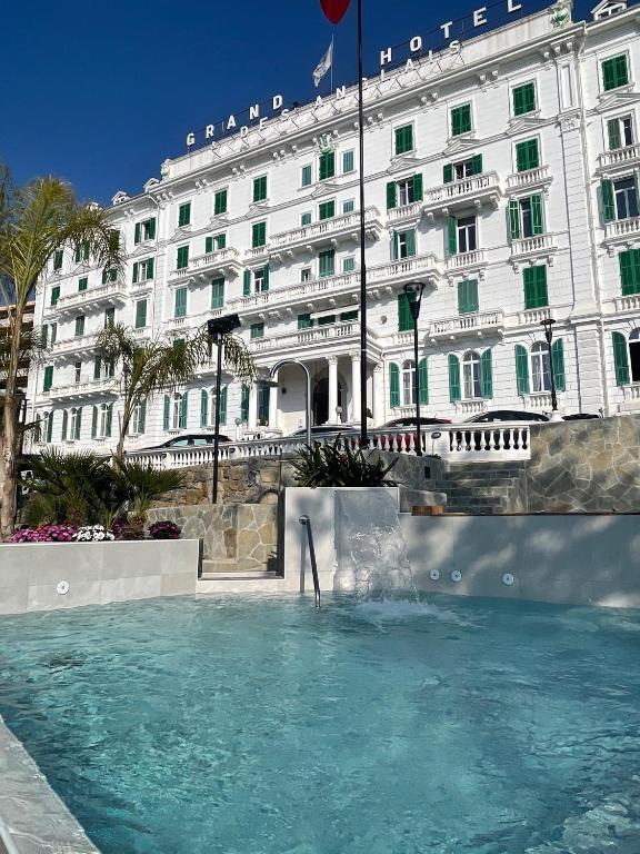 a hotel with a swimming pool in front of a building at Grand Hotel & des Anglais Spa in Sanremo