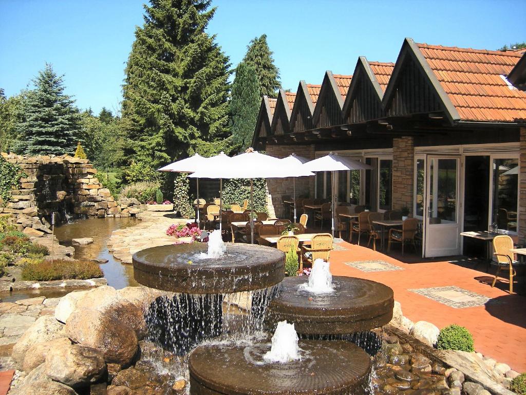 a patio with two water fountains in front of a house at Hotel Hubertushof in Ibbenbüren