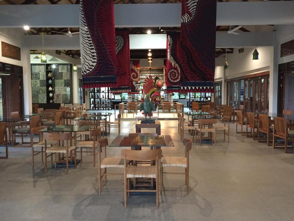 Jiwa Jawa Resort Ijen في بانيووانجى: غرفة طعام مع طاولات وكراسي في مبنى