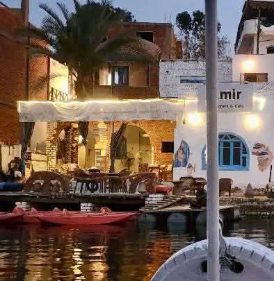 a house with a marina with boats in the water at Amir Nile Guest house in Aswan