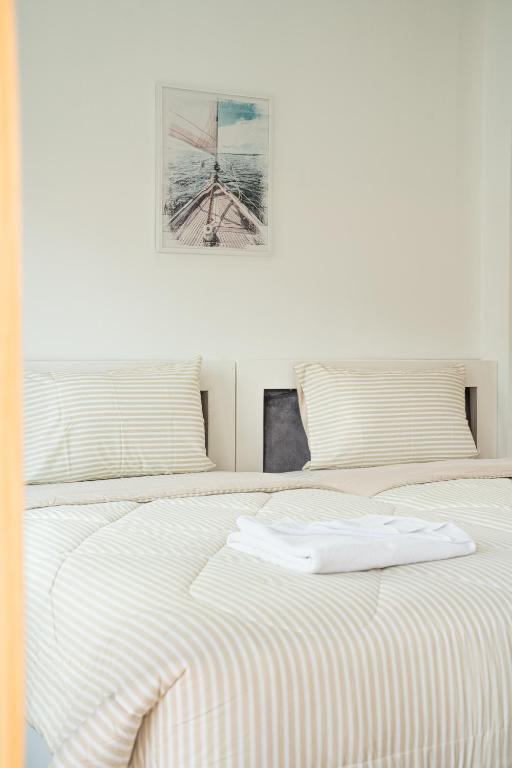 a bedroom with two beds and a picture on the wall at Palai House in Ban Na Bon