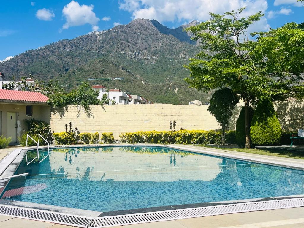a swimming pool with a mountain in the background at Hotel Asia Vaishnodevi Katra in Katra