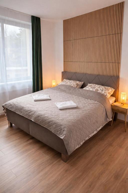 a bedroom with a large bed with two towels on it at VIRIDIS Apartment in Františkovy Lázně