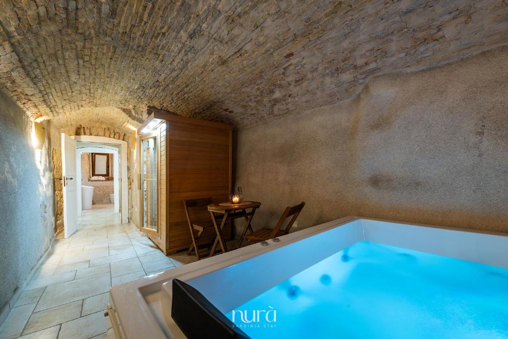 a bath tub in a room with a table at Castello Room & Spa in Cagliari