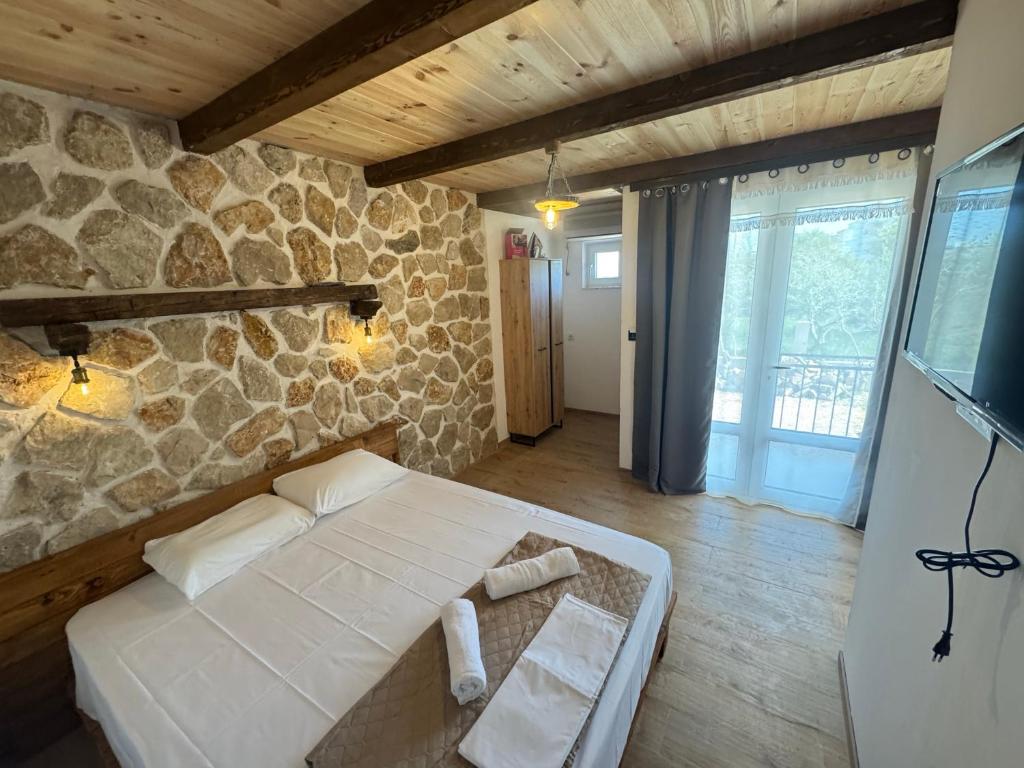 a room with a white bed and a stone wall at Medo in Ulcinj