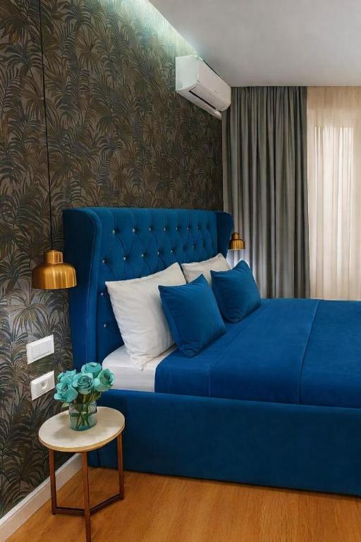 a blue couch in a living room with a table at Hotel Capital Inn Tirana by Arta in Tirana