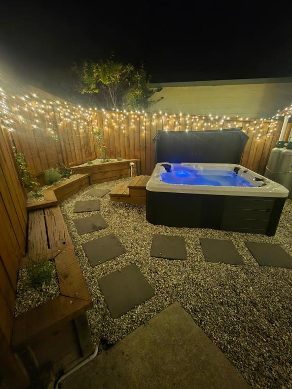 a jacuzzi tub in a backyard with a fence at The Old Tin Shed in Wanaka