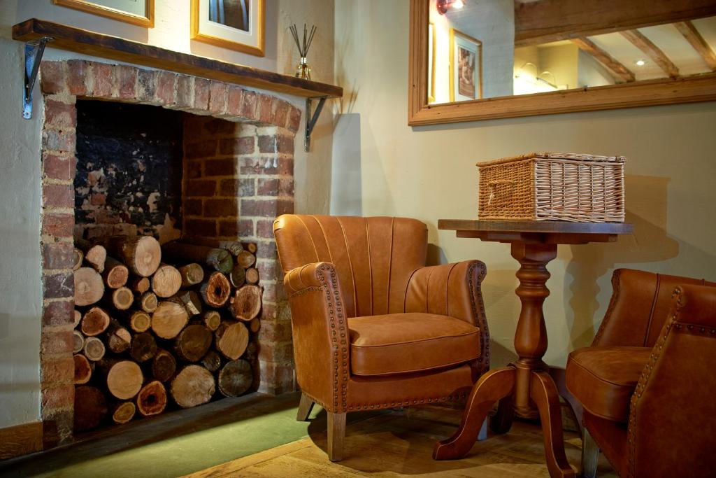 a living room with a chair and a fireplace at Seven Stars in Ledbury