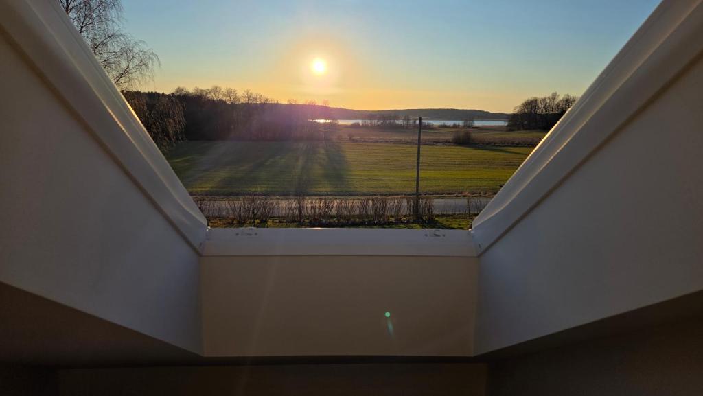 a view of the sunset from a roof at Attic floor with views over fields and sea in Sigtuna