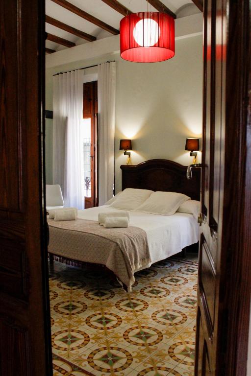 a bedroom with a large bed and a red light at La Casa del Médico in Pego