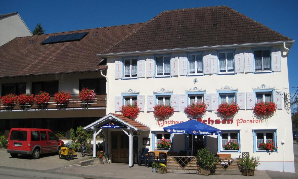 a large white building with flowers in the windows at Pension Ochsen, Gästezimmer in Unadingen in Löffingen