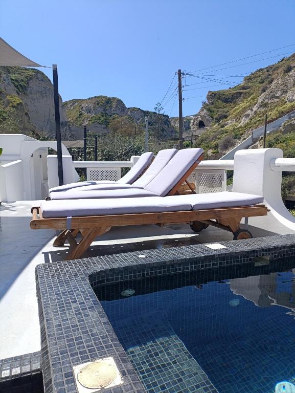a group of lounge chairs sitting next to a swimming pool at Ecolodge Cave House in Vóthon