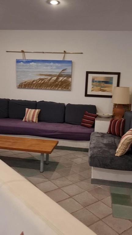 a living room with a purple couch and a coffee table at The happy smile villa in Bella Farnia
