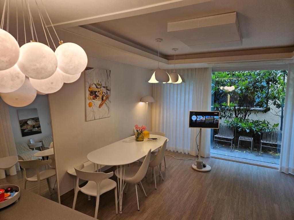 a dining room with a table and chairs and a television at South Sagye Jeju in T'ogi-dong