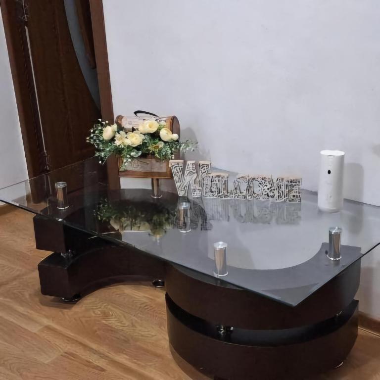 a glass table with wine glasses on top of it at Alexander Residence in Slănic-Moldova