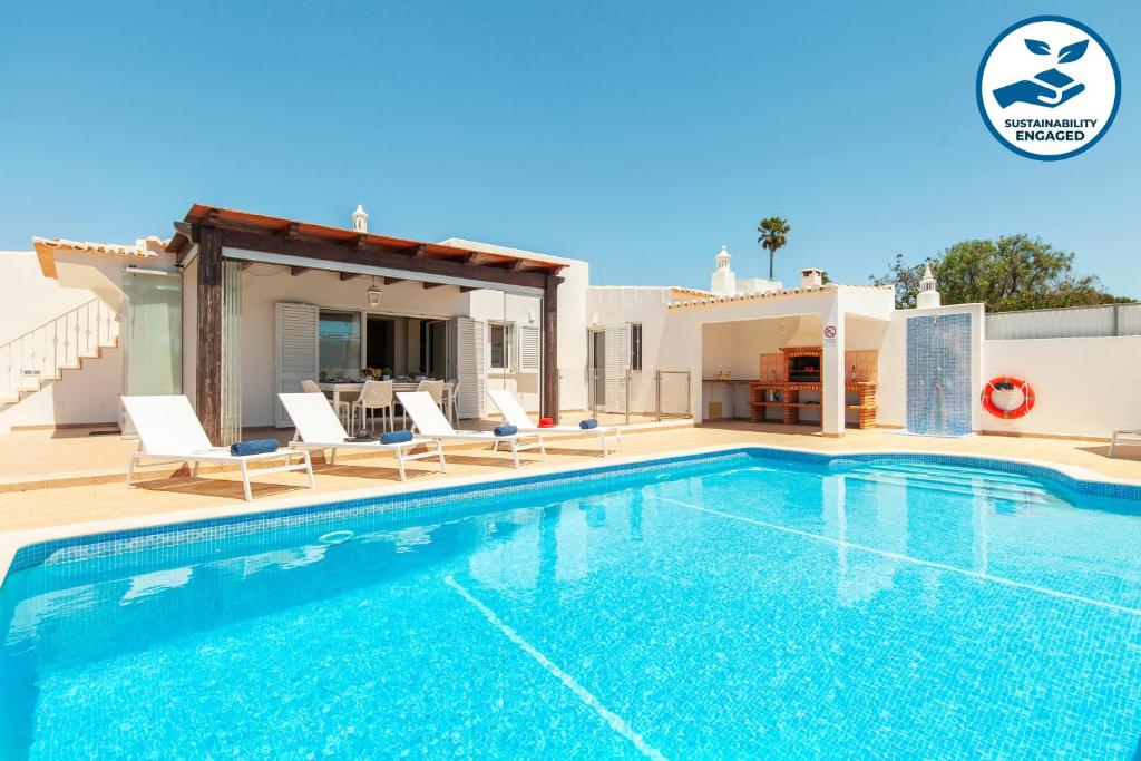 a villa with a swimming pool and a house at Villa Solara - com piscina aquecível e BBQ em Carvoeiro in Carvoeiro