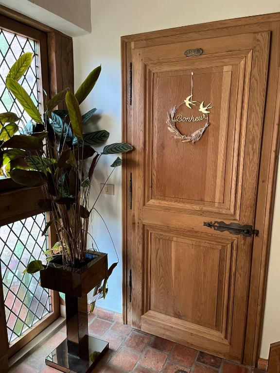 a wooden door with a sign on it next to a plant at SomeTimes in Roeselare