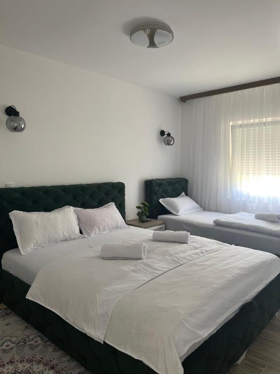 a bedroom with two large beds and a window at Apartmani Zeleni Horizont in Bratunac