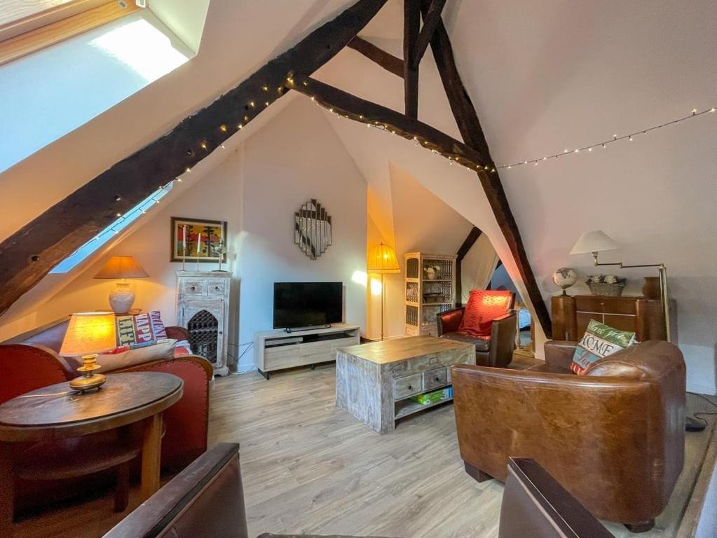 a large living room with a vaulted ceilings and a living room with at Poutres et charme in Paimpol