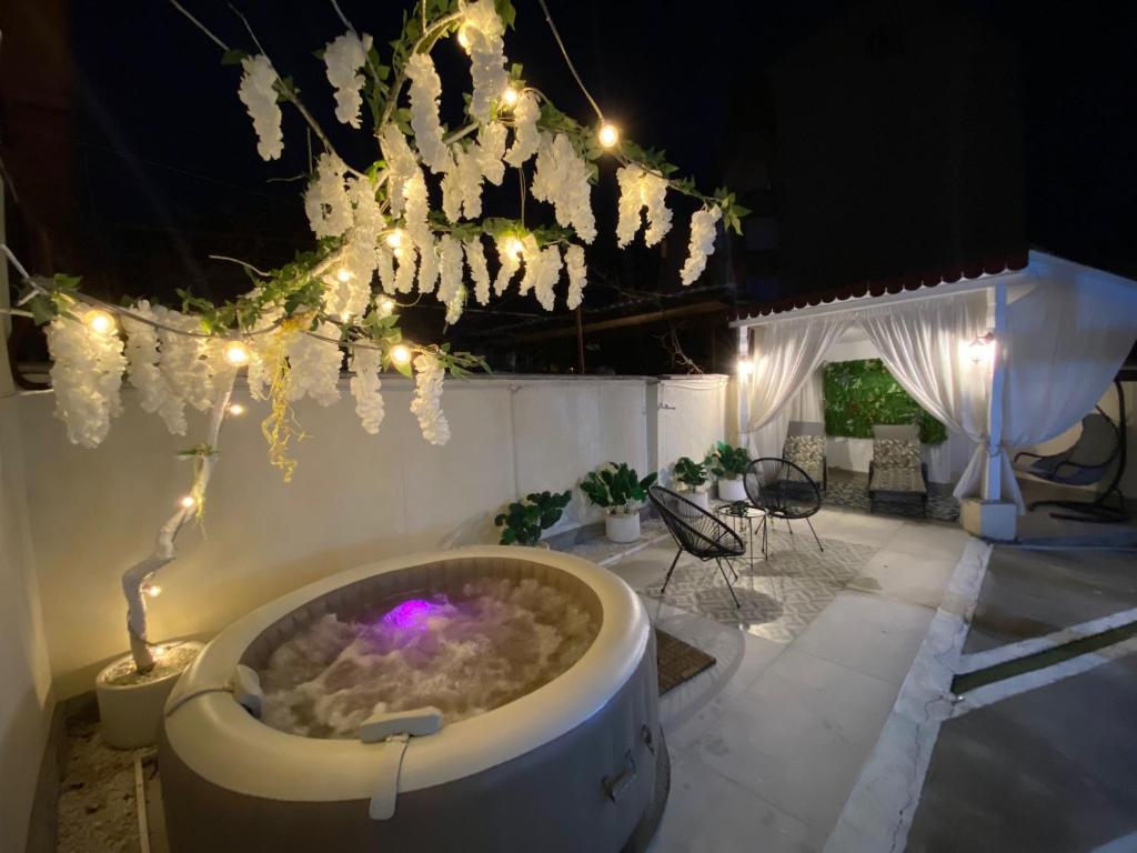 a large bath tub with lights and a table and chairs at Casa Denis la 50m de Castel! in Hunedoara