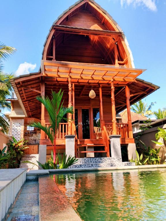 a house with a pool in front of it at Bene Pertiwi Villa in Ubud