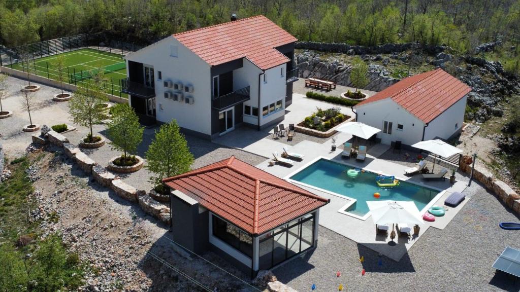 an aerial view of a house with a swimming pool at Vila Agape with a pool, football and tennis court in Lovreć