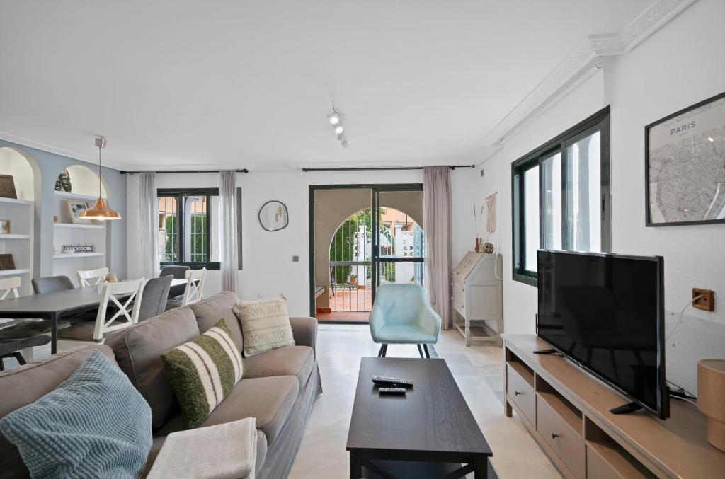 a living room with a couch and a tv at Casa Mar & Golf in San Luis de Sabinillas