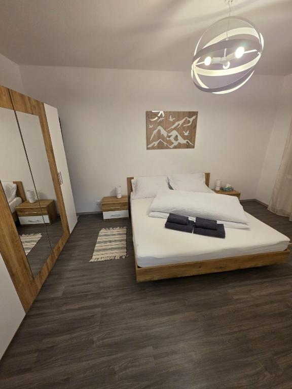 a bedroom with a large bed and a chandelier at Apartmán Jonas - Riegrova 41 in Děčín