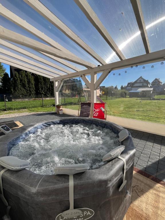 a hot tub under a cover in a backyard at Apartamenty u Petuski z Jacuzzi in Szaflary