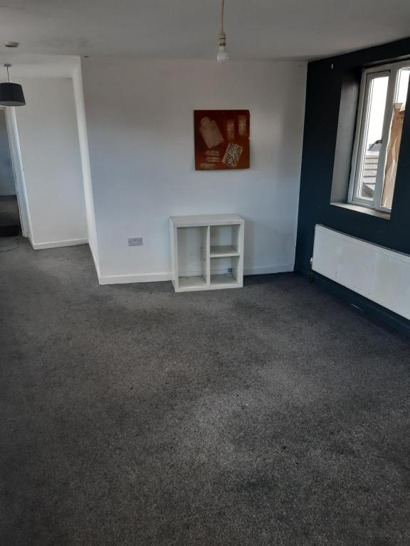 an empty room with a white wall and a window at OG Box in Bolton