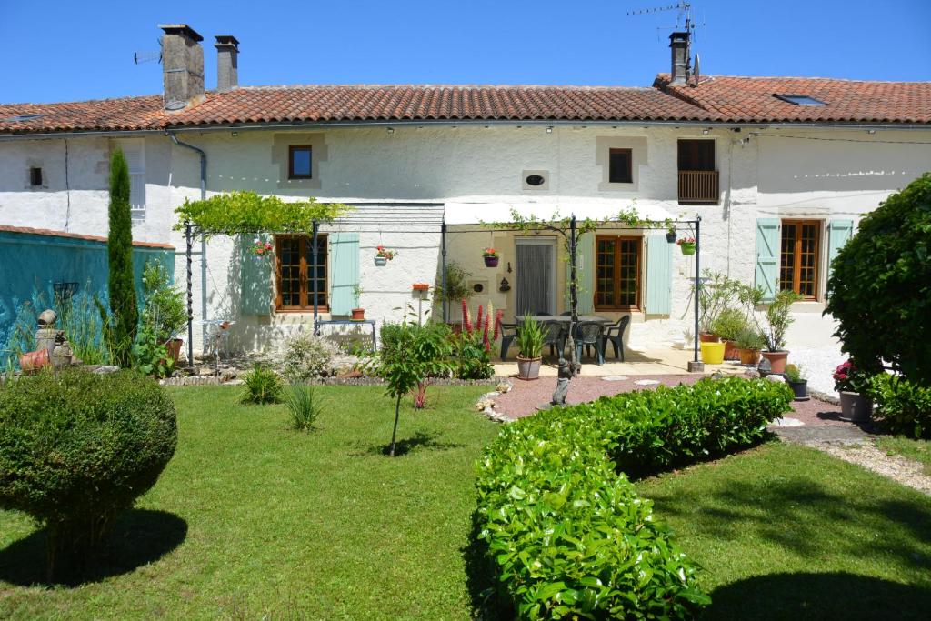a white house with a yard with plants at Large 3 bedroom Cottage near Ruffec in Bernac