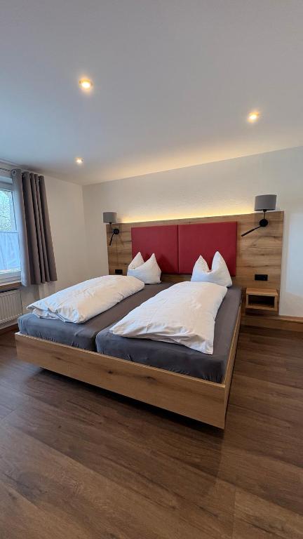 a bedroom with two beds and a red headboard at Gasthof Söll in Niedertaufkirchen