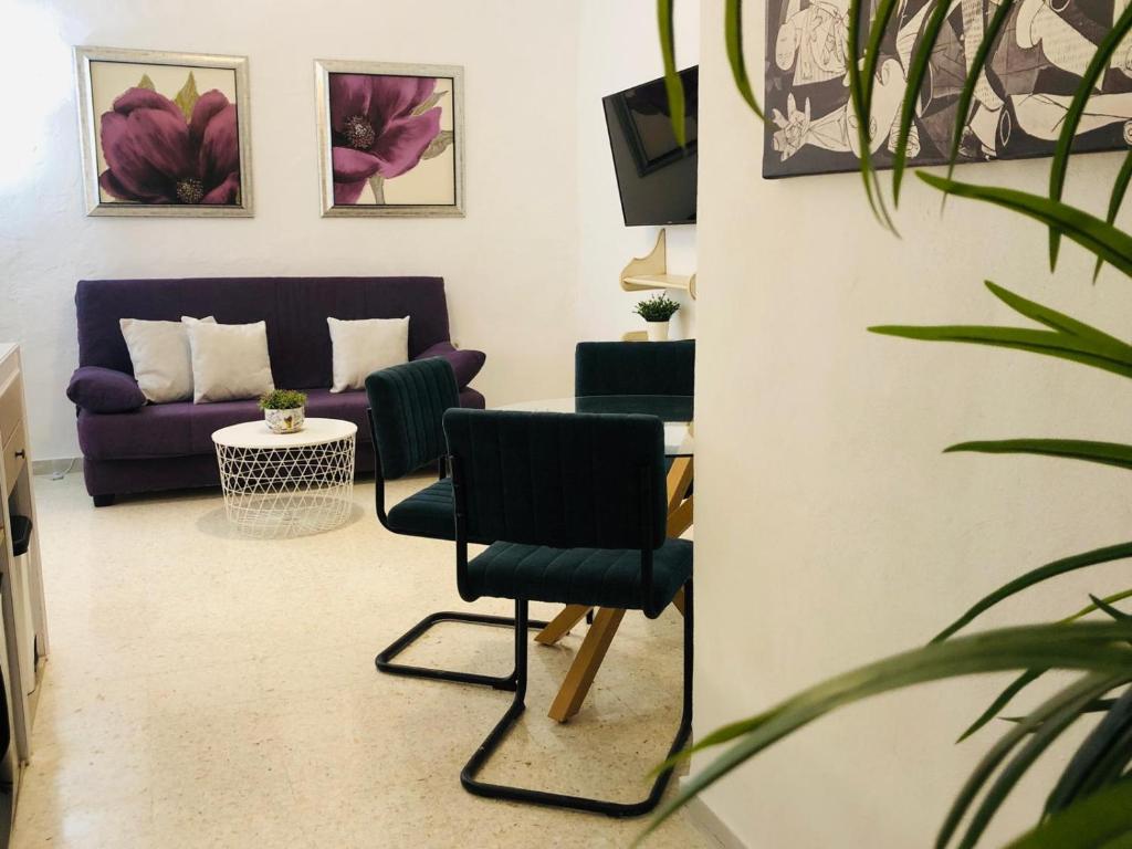a living room with a purple couch and a table at La casa grande 2 in Carmona