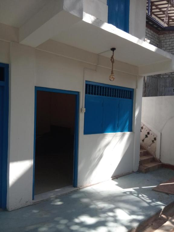 a garage with a blue door in a white wall at Amaya Hotel and Restaurant in Batigama