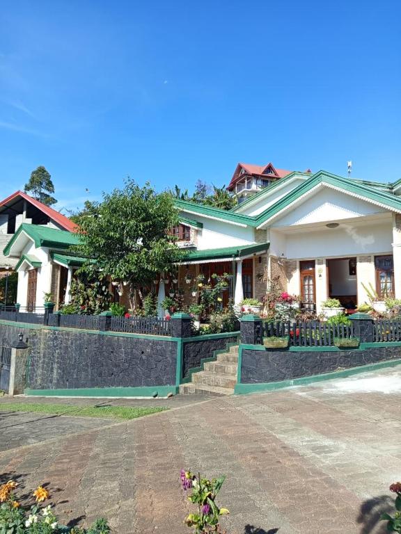a house with flowers in front of it at Little England Grand Hotel in Nuwara Eliya