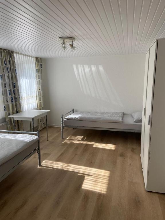 a room with two beds and a table in it at Gemütliche Monteurunterkunft bei Lübeck in Stockelsdorf