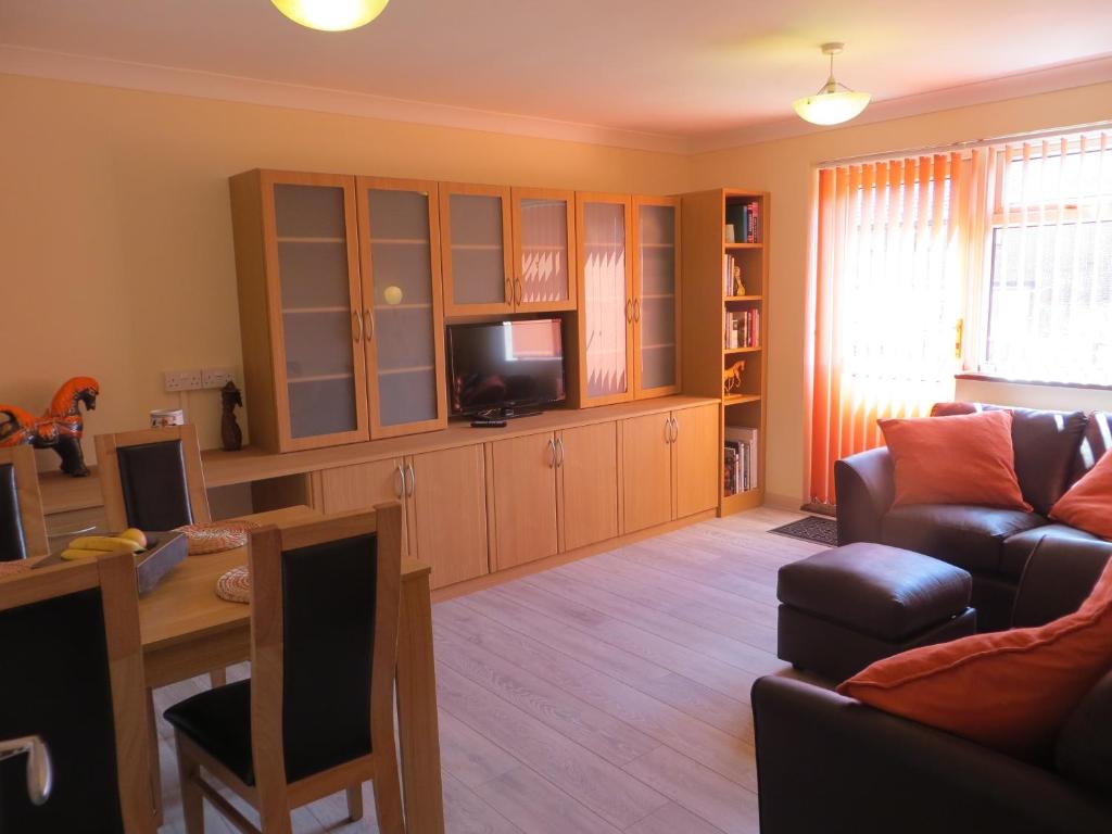 a living room with a couch and a tv at Woodbury Court in Bere Regis