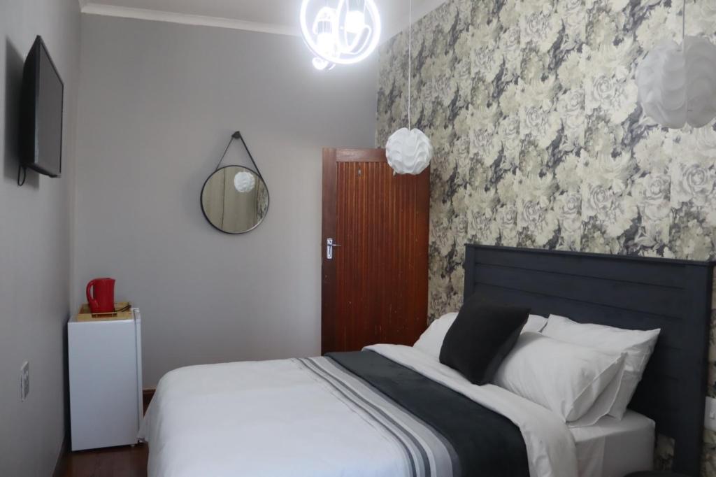 a bedroom with a bed and a wall with flowers at Townside-Estate Room9 in Ladysmith