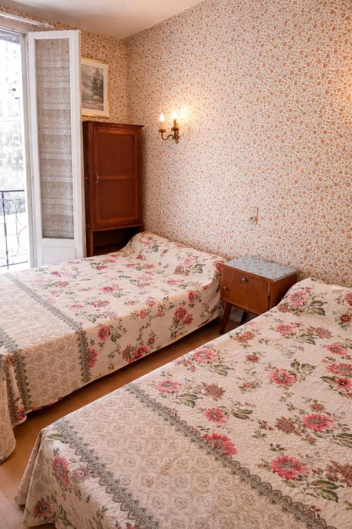a bedroom with two beds and a window at Hotel Saint Francois Xavier in Lourdes