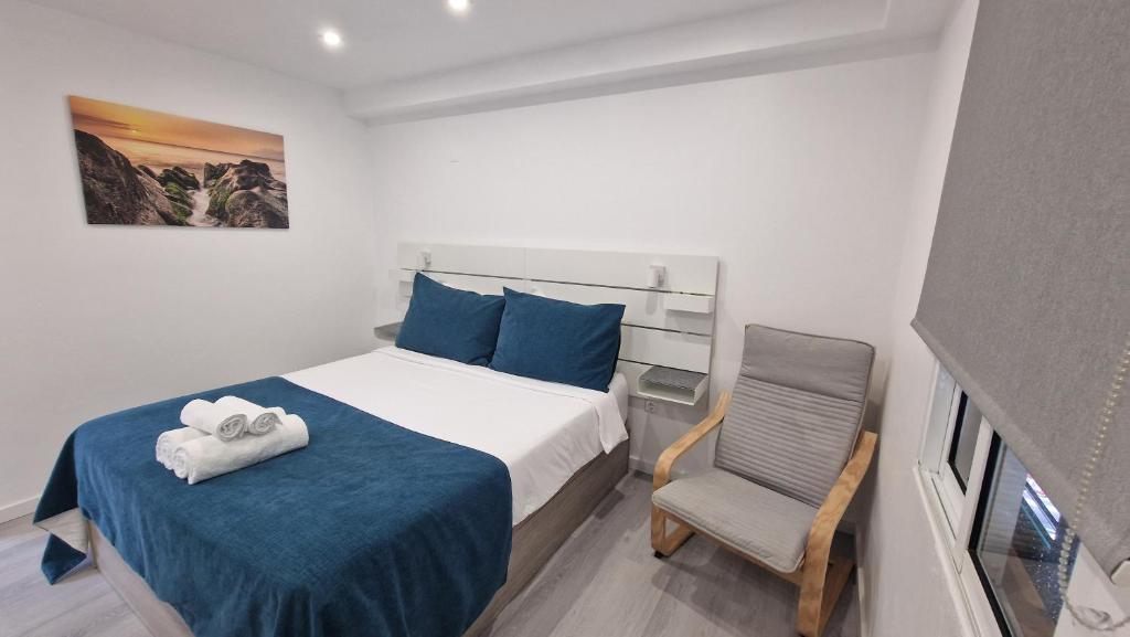 a small bedroom with a bed and a chair at Ocean Breeze in Porto Moniz