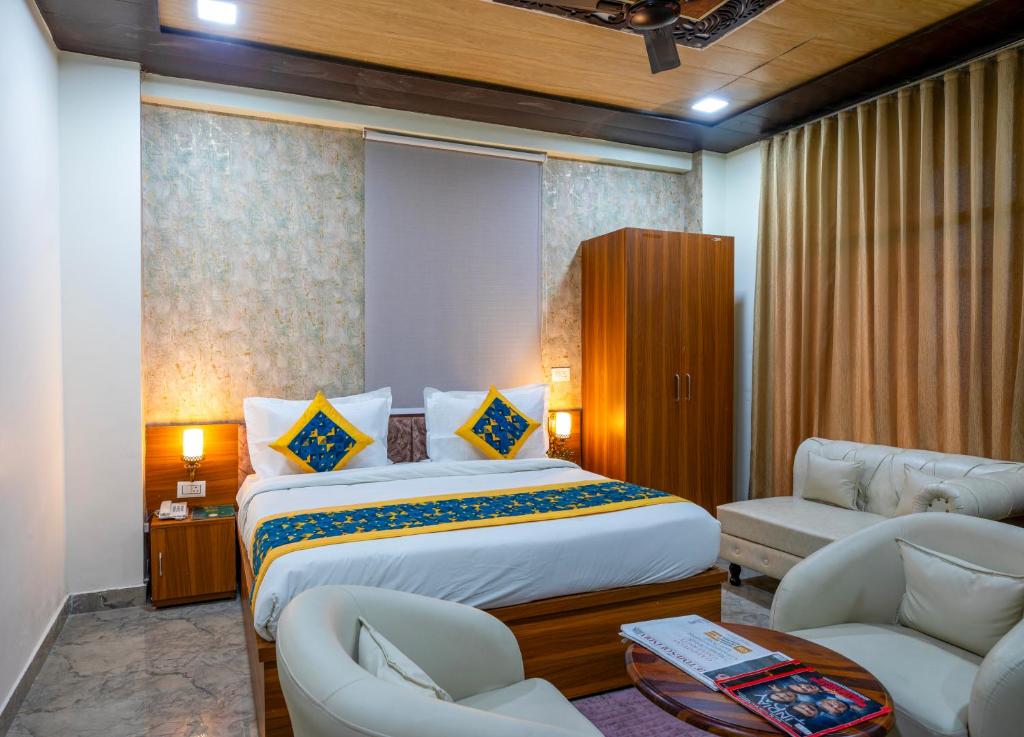a bedroom with a large bed and two chairs at Aarchh Royale in Noida
