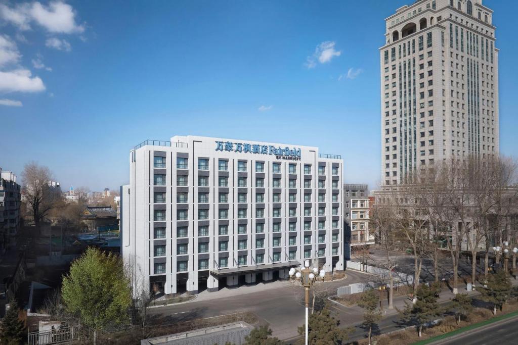 a large white building next to a tall building at Fairfield by Marriott Changchun Chaoyang in Changchun