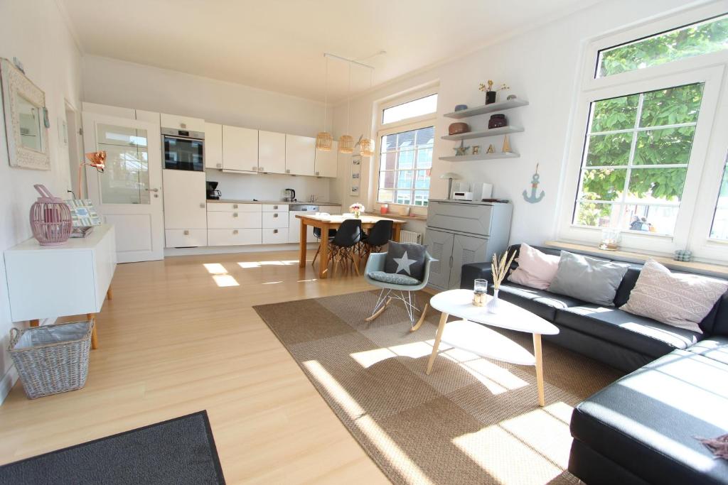 a living room and kitchen with a couch and a table at Langeoog entspannt in Langeoog